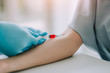© chompoo - Close up Hand of nurse, doctor or Medical technologist in blue gloves taking blood sample from a patient in the hospital.