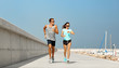 © Syda Productions - sport, technology and lifestyle concept - happy couple with fitness tracker running along pier in summer