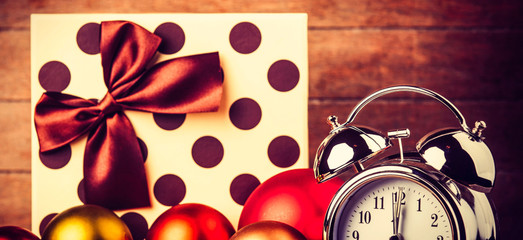 Wall Mural - gray metal alarm clock and Christmas gifts and baubles on a wooden table and background