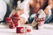 © LIGHTFIELD STUDIOS - selective focus of cups of coffee with woolen cases and legs of couple sitting on floor at home