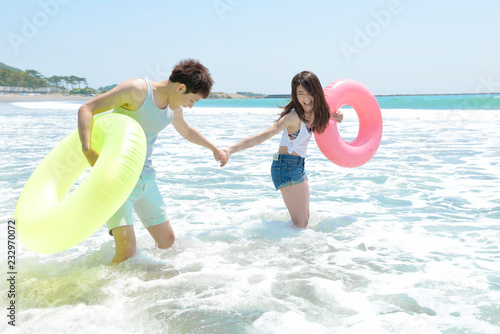 真夏の海で遊ぶ若いカップル Stock 写真 Adobe Stock