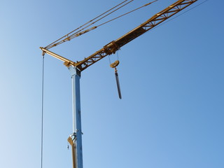 Yellow construction crane against blue sky