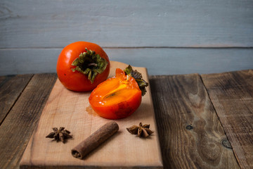 a ripe sliced persimmon on a wooden background