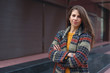 © diignat - Crossed arms young woman posing on urban background