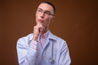 © Ranta Images - Young handsome androgynous man doctor against brown background