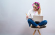 © Tierney - Young woman studying on her laptop computer on a gray background