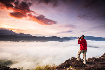 The man are taking photos  the sea of mist on high mountain in Nakornchoom, Phitsanulok province, Thailand.