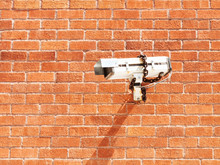 Surveillance Camera On Red Brick Wall