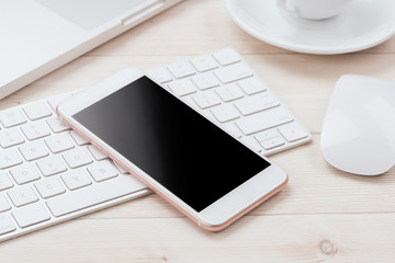 Working table with smart phone, laptop, a cup of coffee and supplies