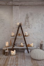 Lit Candles On Home-made Shelving With White Shelves In Rustic Atmosphere