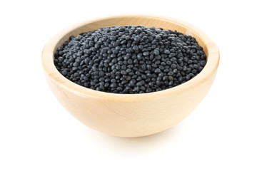 Heap of black organic beluga lentils in wooden bowl on white