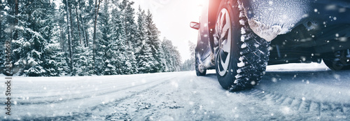 Fotomural Closeup of car tires in winter on the road covered with snow