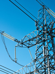 Close up view of electricity pylon with blue sky background