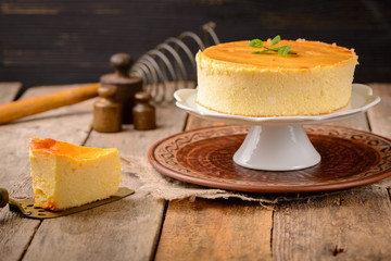 Wall Mural - Homemade round cheesecake with mint for dessert - healthy organic summer dessert pie cheesecake. Country style.