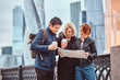 © Fxquadro - Group of tourists searching place on the map in front of skyscrapers
