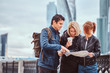 © Fxquadro - Group of tourists searching place on the map in front of skyscrapers