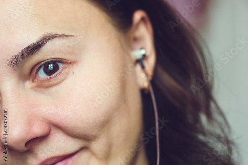 Beautiful Girl A Young Lady With Gold Colored Headphones On Her Ears Half Face Is In