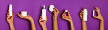 Female Hands Holding White Cosmetics Bottles - Lotion, Cream, Serum On Violet Background. Banner. Skin Care, Pure Beauty, Body Treatment Concept