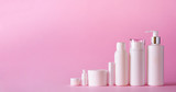 Fototapeta  - White cosmetic tubes on pink background with copy space. Skin care, body treatment, beauty concept. Banner