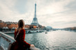 © Masson - Style redhead girl in red coat and bag at parisian street with view at Eiffel tower in autumn season time