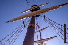 View Of A Ship Mast With Two Spars, Shrouds And Collapsed Sails From Below.