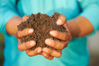 Close up of the hand of a farmer holding a handful of rich fertile soil