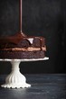 © Foodlovers - Chocolate glaze poured over chocolate cake on cake stand