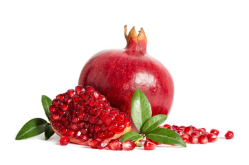 one whole and part of a pomegranate with pomegranate seeds and leaves isolated on white background