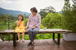 © Somkiat - Happy grandmother with granddaughter sitting on a bench in summer park. Happy senior lady playing with little girl in outdoors cafe.