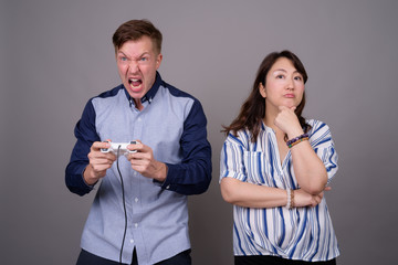 Portrait of multi ethnic diverse couple playing video games