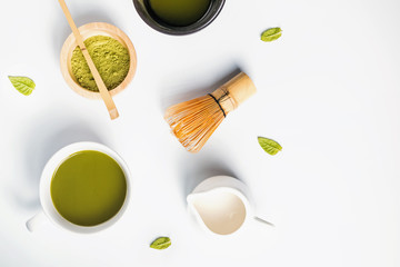 Powder, green tea and milk on the white background, top view