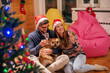 © Dusan Petkovic - Couple sitting on the floor and drinking champagne. Man holding dog.