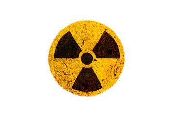 Round yellow and black radioactive (ionizing radiation) nuclear danger symbol on rusty metal grungy texture and isolated on white background.