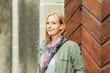© annanahabed - Outdoor portrait of beautiful blond woman, posing outdoors, wearing khaki color parka and pink scarf