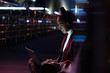 © LIGHTFIELD STUDIOS - attractive asian girl in kimono sitting and using laptop with headphones on street with neon light, city of future concept