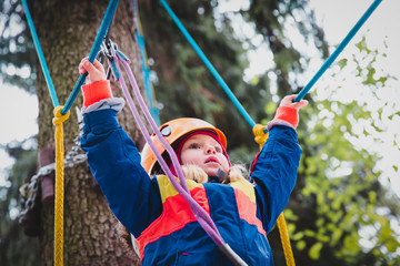 little girl climbing in adventure activity park