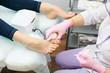 © Semenova Jenny - The doctor in the salon applies a foot cream during a pedicure