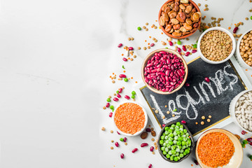 Sticker - Various assortment of legumes - beans, soy beans, chickpeas, lentils, green peas. Healthy eating concept. Vegetable proteins. White marble background copy space top view