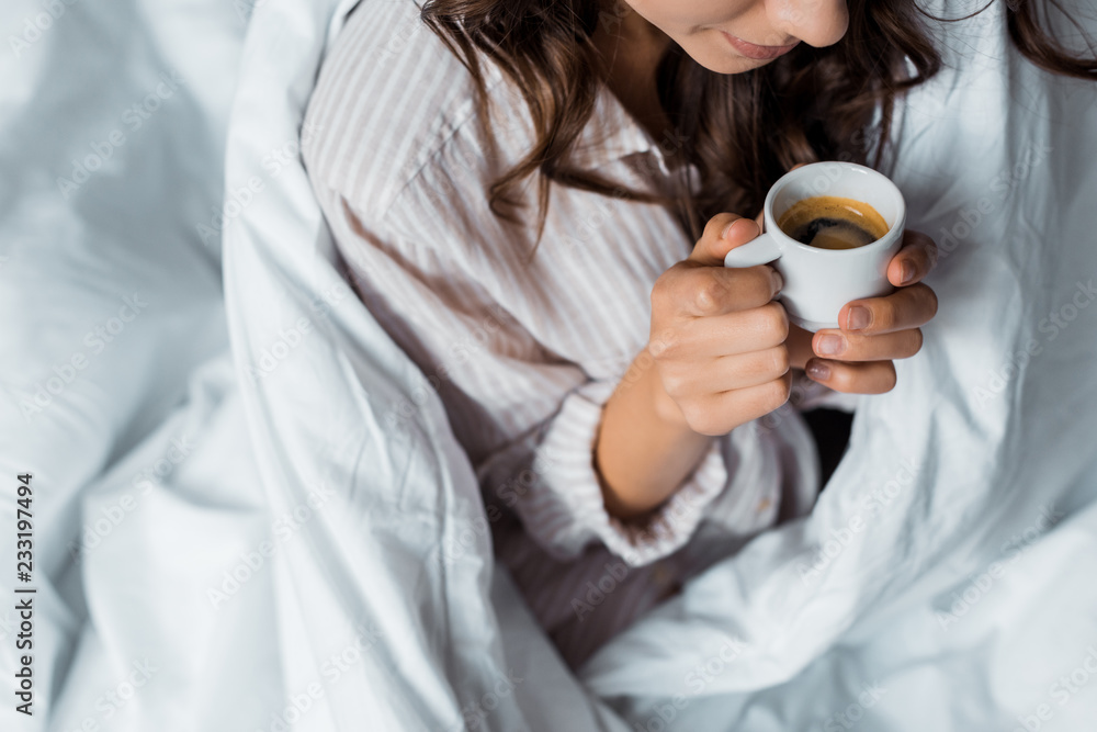cropped view of girl holding cup of espresso coffee in the morning - obrazy, fototapety, plakaty 