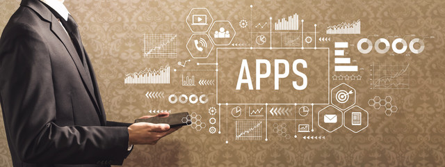 Apps with businessman holding a tablet computer on a dark vintage background