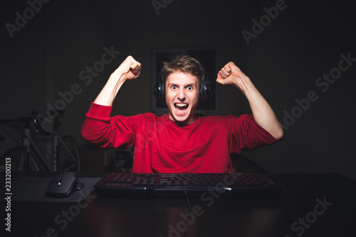 Foto Portrait of an emotional gamer rejoicing with his hands up