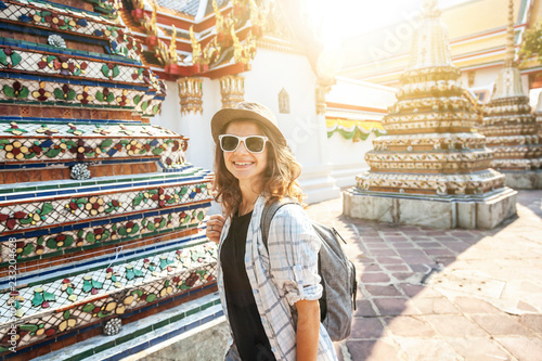 Photo Young beautiful happy smiling european woman in a hat and glasses at a buddhist