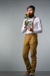A man with a beard holds a yellow rose