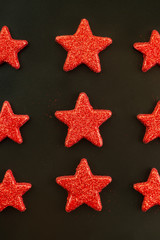 Nine red stars on black background. Flat lay. View from above