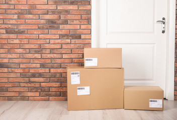 Poster - Cardboard parcel boxes on floor near apartment entrance. Mockup for design