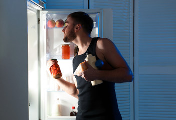 Sticker - Man taking products out of refrigerator in kitchen at night