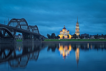 Fototapete - Rybinsk, Russia. Spaso-Preobrazhenskiy cathedral and bridge over Volga river reflecting in water at dsuk 