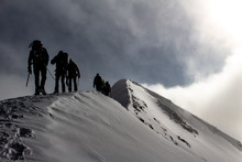 Mountaineers On A Snowy Mountain Ridge