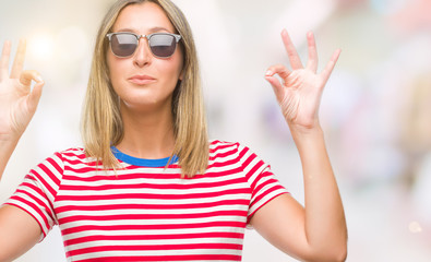 Poster - Young beautiful woman wearing sunglasses over isolated background relax and smiling with eyes closed doing meditation gesture with fingers. Yoga concept.