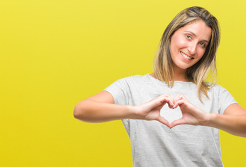 Poster - Young beautiful woman over isolated background smiling in love showing heart symbol and shape with hands. Romantic concept.